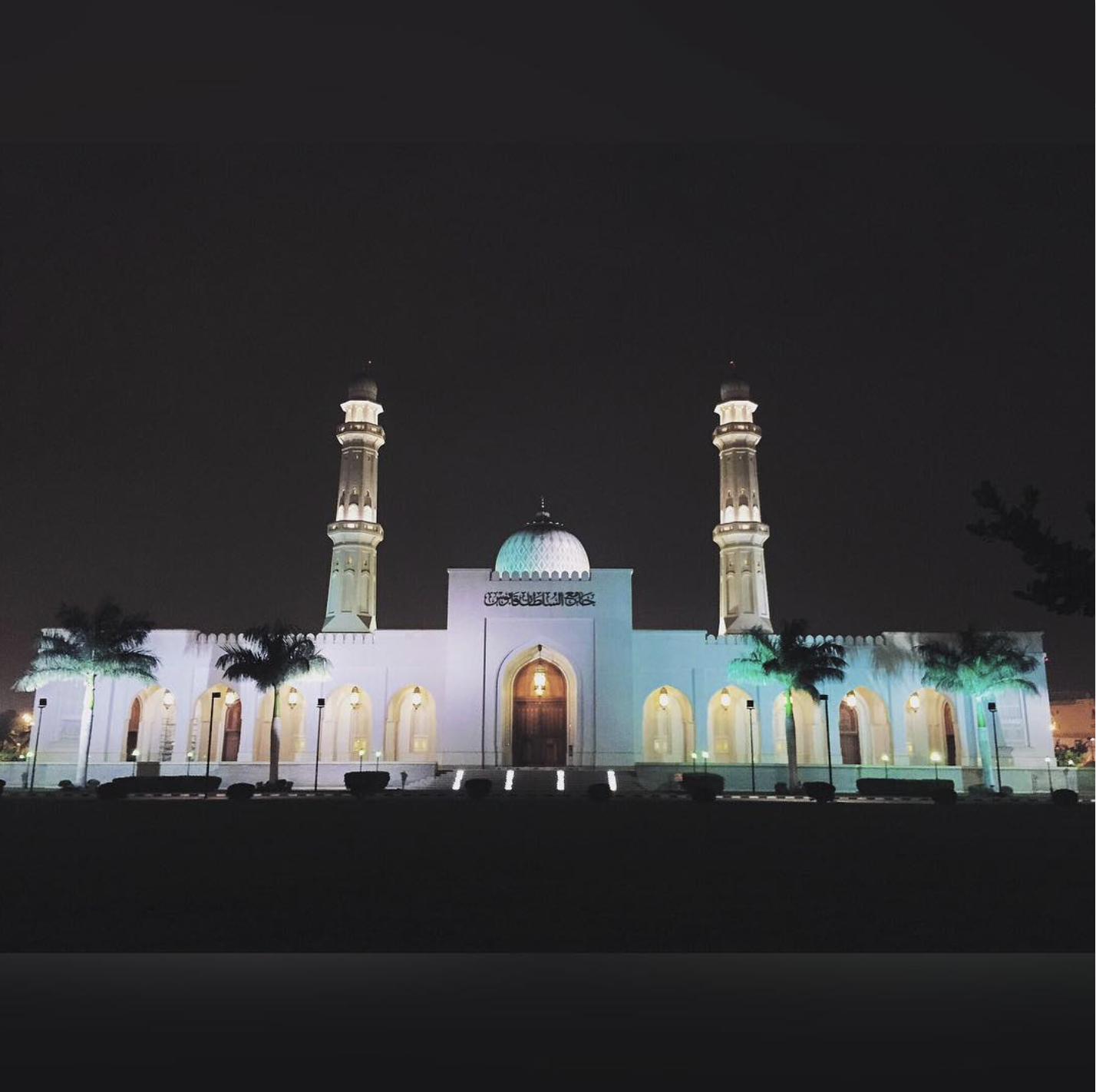 a white building with towers and a dome at night